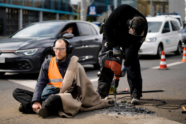 police-removes-the-pavement-next-to-the-hand-of-a-climate-activist-during-a-protest-against-the-climate-policy-of-the-german-government-in-berlin-germany-monday-april-24-2023-german-climate-activ