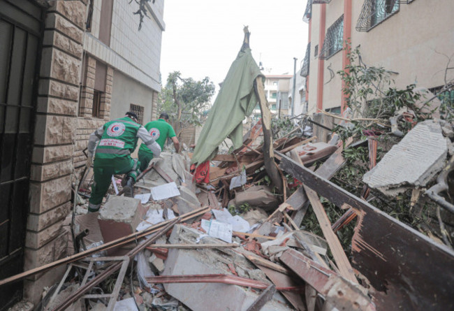 palestinian-paramedics-inspect-damage-in-a-building-following-israeli-airstrikes-on-an-apartment-of-an-islamic-jihad-commander-in-gaza-city-israeli-air-strikes-killed-13-people-before-dawn-on-may-9