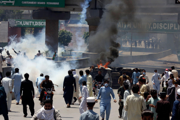 supporters-of-pakistans-former-prime-minister-imran-khan-walk-next-to-a-burning-car-during-a-protest-against-the-arrest-of-their-leader-in-peshawar-pakistan-wednesday-may-10-2023-pakistan-brace