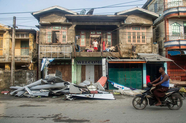 a-local-rides-motorbike-past-damaged-buildings-after-cyclone-mocha-in-sittwe-township-rakhine-state-myanmar-monday-may-15-2023-rescuers-on-monday-evacuated-about-1000-people-trapped-by-seawater