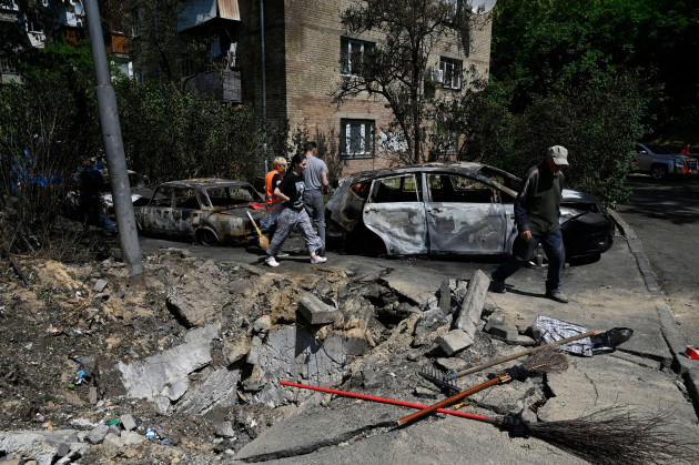 kyiv-ukraine-30th-may-2023-people-walk-near-burned-out-cars-damaged-by-fragments-of-a-downed-kamikaze-drone-of-the-russian-army-russia-attacked-the-ukrainian-capital-with-iranian-strike-drones-t