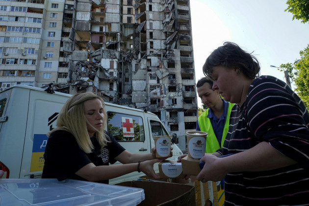 local-residents-get-free-meals-from-volunteers-against-the-background-of-their-apartment-house-damaged-in-the-russian-rocket-attack-in-kharkiv-ukraine-friday-june-2-2023-ap-photoandrii-marien
