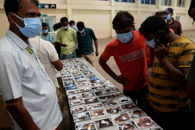 people-look-at-the-photographs-of-the-passengers-who-were-traveling-in-the-trains-that-got-derailed-for-identification-in-balasore-district-in-the-eastern-indian-state-of-orissa-sunday-june-4-2023