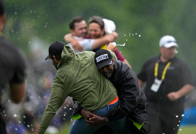 canadian-professional-golfer-adam-hadwin-left-is-stopped-by-a-security-guard-while-he-tries-to-celebrates-with-nick-taylor-of-canada-after-taylor-won-the-canadian-open-golf-tournament-in-toronto
