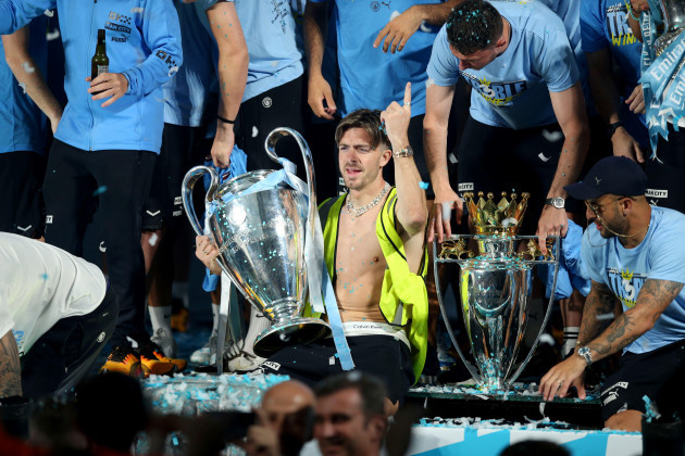 manchester-citys-jack-grealish-celebrates-on-stage-with-their-trophies-during-the-treble-parade-in-manchester-manchester-city-completed-the-treble-champions-league-premier-league-and-fa-cup-after