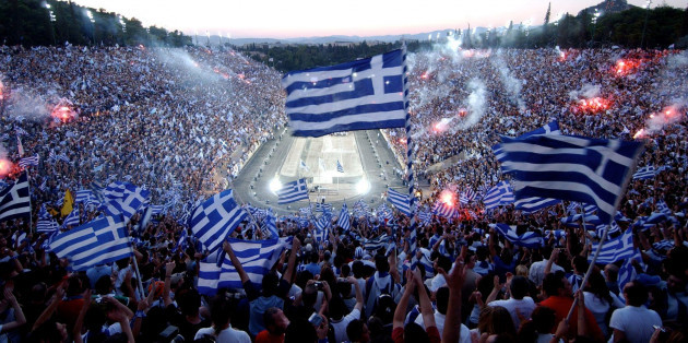 file-tens-of-thousands-of-fans-wave-greek-flags-and-flares-at-the-all-marble-panathenian-stadium-where-the-first-modern-olympics-were-held-in-1896-to-welcome-greeces-national-soccer-team-after