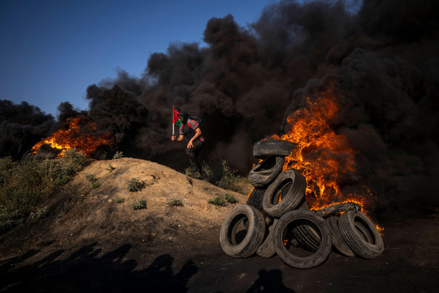 palestinians-burn-tires-and-wave-the-national-flag-during-a-protest-against-an-israeli-military-raid-in-the-west-bank-city-of-jenin-along-the-border-fence-with-israel-in-east-of-gaza-city-monday-j