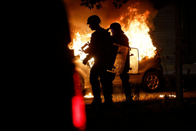 riot-police-stand-near-a-burning-car-in-the-la-meinau-neighborhood-of-strasbourg-eastern-france-on-friday-june-30-2023-young-rioters-clashed-with-police-and-looted-stores-friday-in-a-fourth-day-o