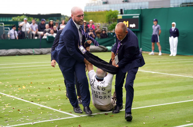 a-just-stop-oil-protester-is-carried-off-court-18-after-throwing-confetti-on-to-the-grass-during-katie-boulters-first-round-match-against-daria-saville-on-day-three-of-the-2023-wimbledon-championship