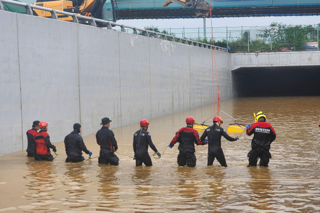 in-this-photo-provided-by-south-korea-national-fire-agency-rescuers-search-for-survivors-along-a-road-submerged-by-floodwaters-leading-to-an-underground-tunnel-in-cheongju-south-korea-sunday-july