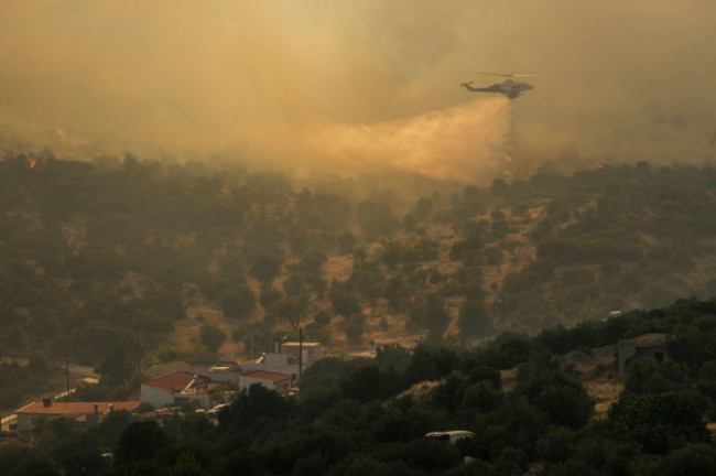 a-firefighting-helicopter-dumps-water-in-mandra-west-of-athens-on-tuesday-july-18-2023-in-greece-where-a-second-heatwave-is-expected-to-hit-thursday-three-large-wildfires-burned-outside-athens-f