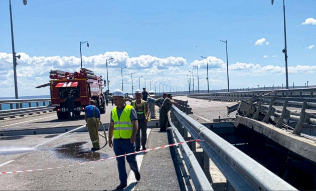 in-this-image-from-a-video-released-on-wednesday-july-19-2023-by-russian-national-antiterrorism-committee-employees-work-at-the-damaged-parts-of-an-automobile-link-of-the-crimean-bridge-connecting