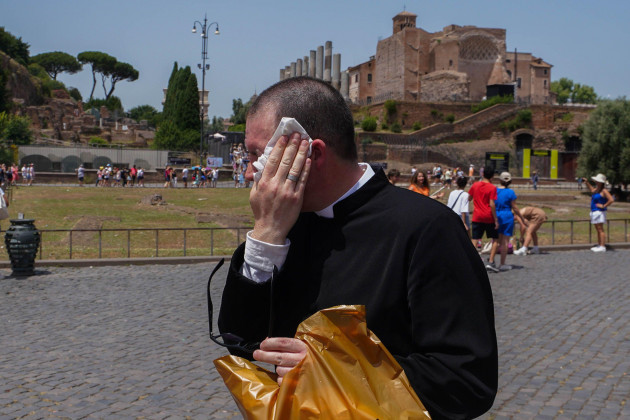 rome-italy-12-july-2023-a-priest-wipes-the-sweat-from-his-face-as-rome-experiences-high-temperatures-the-italian-health-ministry-has-issued-a-red-alert-heatwave-warning-for-eight-major-cities-in