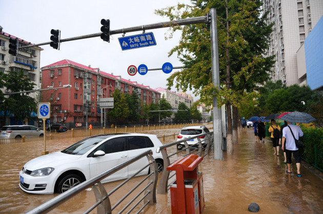 beijing-china-31st-july-2023-passengers-walk-past-cars-submerged-in-floodwater-in-mentougou-district-of-beijing-capital-of-china-july-31-2023-by-4-p-m-monday-the-chinese-capital-had-seen-40