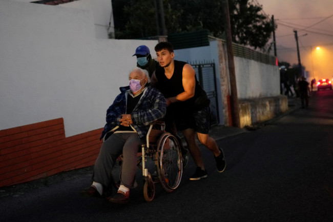 local-people-are-evacuated-as-the-fire-approaching-to-their-houses-in-alcabideche-outside-lisbon-tuesday-july-25-2023-hundreds-of-firefighters-and-over-a-dozen-airplanes-were-fighting-a-wildfire