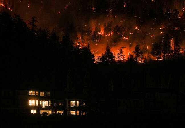 the-mcdougall-creek-wildfire-burns-on-the-mountainside-above-a-home-in-west-kelowna-b-c-on-friday-aug-18-2023-thousands-have-fled-driving-hundreds-of-kilometers-miles-to-safety-or-waiting-in