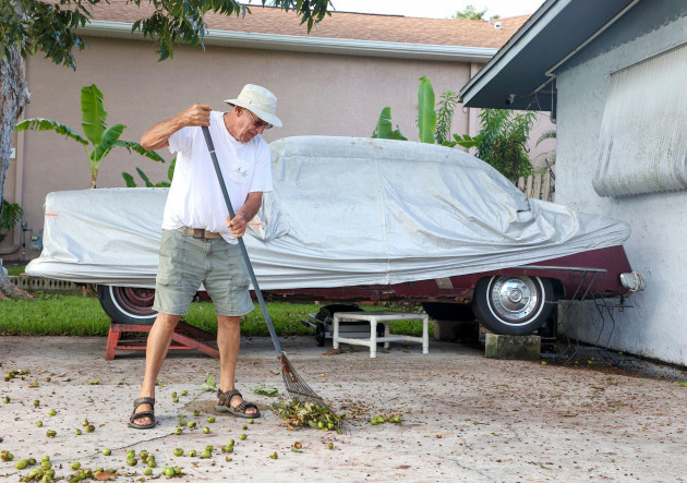 garry-sears-78-collects-fallen-pecans-from-his-pecan-tree-on-monday-aug-28-2023-near-his-collectible-1953-ford-sedan-which-he-has-elevated-to-keep-out-of-storm-surge-sears-who-said-he-had-four
