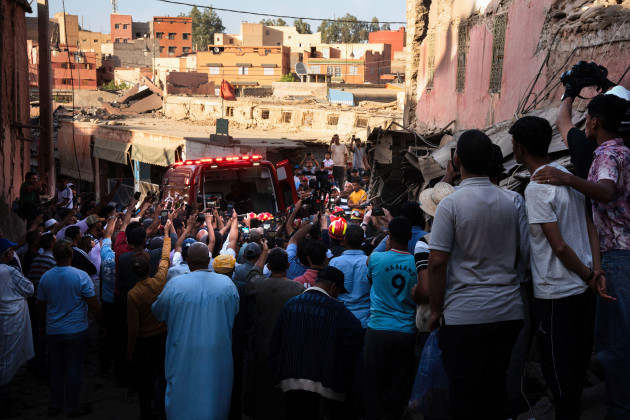 amizmiz-morocco-10th-sep-2023-dozens-of-people-journalists-and-neighbours-take-pictures-as-firefighters-remove-the-body-of-a-man-in-the-moroccan-village-of-amizmiz-one-of-the-worst-hit-by-the-e
