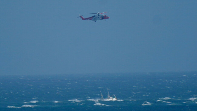 a-helicopter-from-the-irish-coast-guard-hovers-above-a-stranded-boat-off-the-coast-of-blackwater-wexford-a-major-multi-agency-operation-is-underway-off-the-coast-of-wexford-after-a-boat-ran-aground