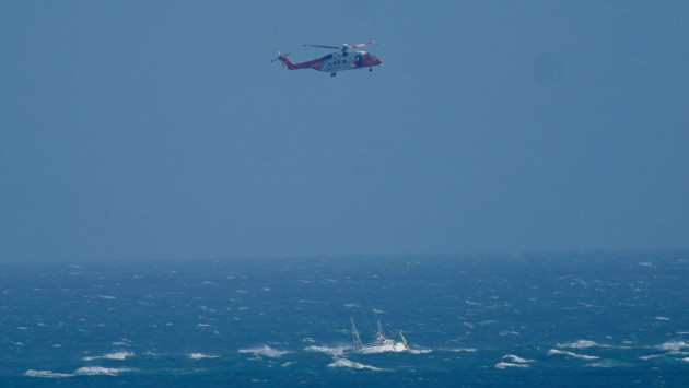 a-helicopter-from-the-irish-coast-guard-hovers-above-a-stranded-boat-off-the-coast-of-blackwater-wexford-a-major-multi-agency-operation-is-underway-off-the-coast-of-wexford-after-a-boat-ran-aground