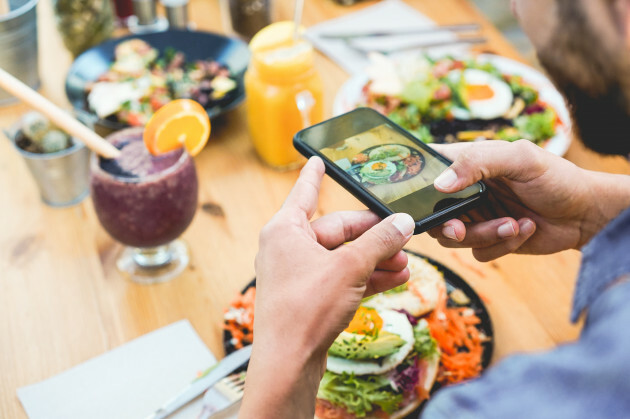 influencermaneatingbrunchwhilemakingvideoandphotosof
