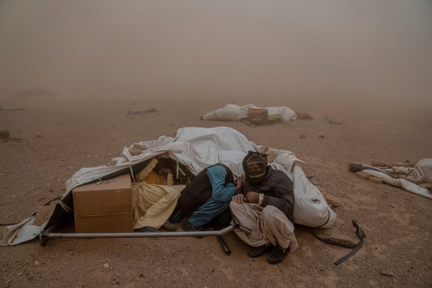 afghan-people-affected-by-the-earthquake-take-shelter-in-their-tent-from-a-powerful-sandstorm-after-an-earthquake-in-zenda-jan-district-in-herat-province-western-of-afghanistan-thursday-oct-12-2