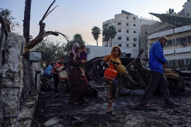 palestinians-carry-belongings-as-they-leave-al-ahli-hospital-which-they-were-using-as-a-shelter-in-gaza-city-wednesday-oct-18-2023-the-hamas-run-health-ministry-says-an-israeli-airstrike-caused
