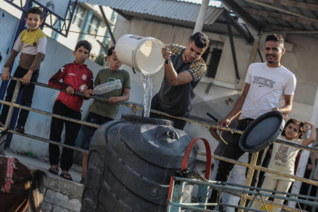 khan-yunis-palestinian-territories-18th-oct-2023-palestinians-fill-containers-with-drinking-water-from-a-water-distribution-vehicle-amid-the-water-crisis-caused-by-the-israeli-siege-on-the-gaza-s