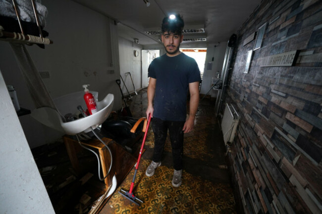 firat-freddie-uygun-inside-his-barber-shop-fresh-n-freddie-on-main-street-in-midleton-co-cork-damaged-by-flooding-after-storm-babet-the-second-named-storm-of-the-season-swept-in-picture-date-t