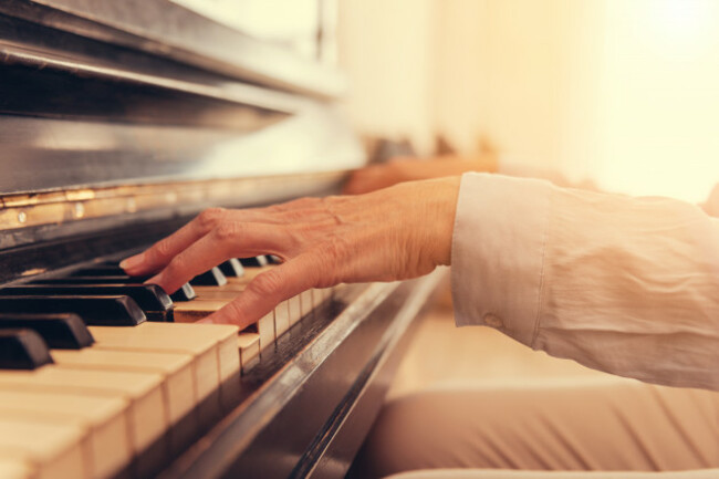closeupofseniorwomanplayingthepiano