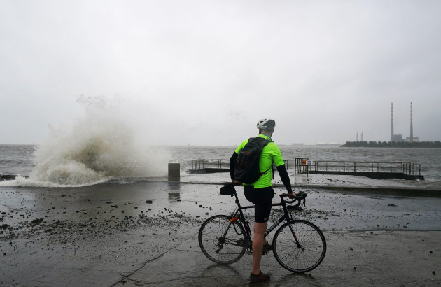 a-cyclist-stops-to-watch-as-waves-crash-onto-clontarf-promenade-in-dublin-as-irelands-meteorological-agency-has-issued-fresh-weather-warnings-for-intense-rain-days-after-parts-of-the-country-were-se