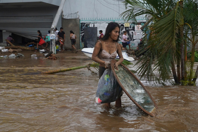 a-woman-walks-away-with-stuff-she-looted-from-a-furniture-store-after-hurricane-otis-ripped-through-acapulco-mexico-wednesday-oct-25-2023-hurricane-otis-ripped-through-mexicos-southern-pacific