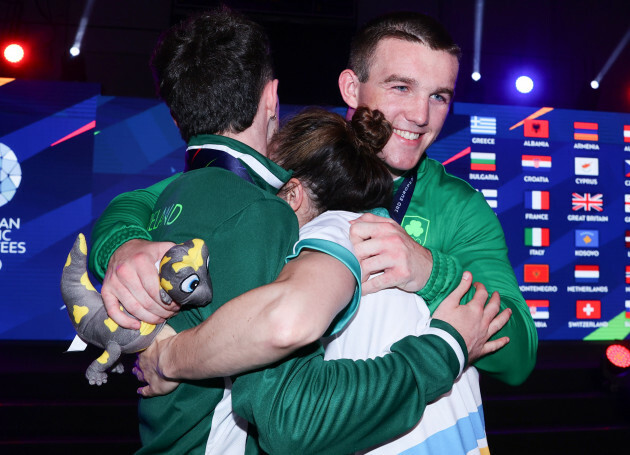 dean-clancy-kellie-harrington-and-jack-marley-share-a-hug-together-after-the-medal-ceremony