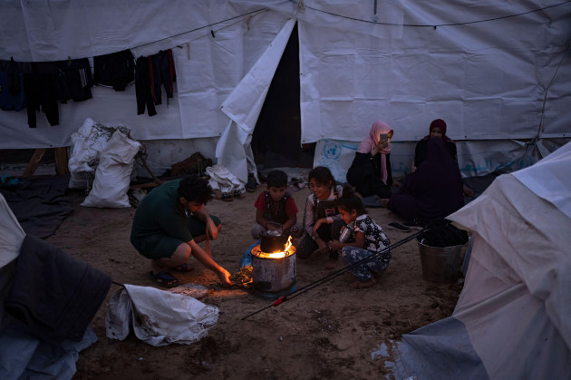 palestinians-displaced-by-the-israeli-bombardment-of-the-gaza-strip-sit-by-a-fire-in-a-undp-provided-tent-camp-in-khan-younis-tuesday-oct-31-2023-ap-photofatima-shbair