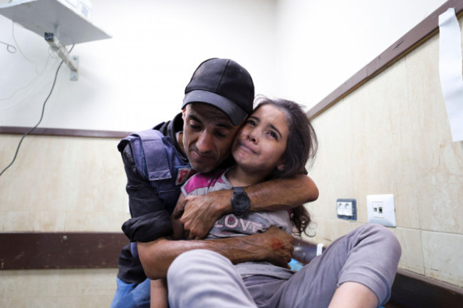 a-palestinian-journalist-comforts-his-niece-wounded-in-an-israeli-strike-on-her-family-home-in-nusseirat-refugee-camp-in-a-hospital-in-deir-el-balah-gaza-strip-sunday-oct-22-2023-ap-photoali