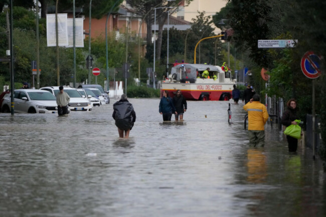 people-make-their-way-on-a-flooded-street-in-campi-di-bisenzio-in-the-central-italian-tuscany-region-friday-nov-3-2023-record-breaking-rain-provoked-floods-in-a-vast-swath-of-tuscany-as-storm-ci