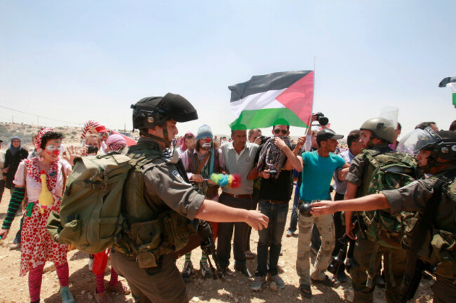 an-israeli-border-policeman-passes-a-tear-gas-grenade-to-another-as-palestinian-israeli-and-foreign-peace-activists-look-on-during-a-protest-against-the-israeli-intention-to-demolish-the-west-bank-vi