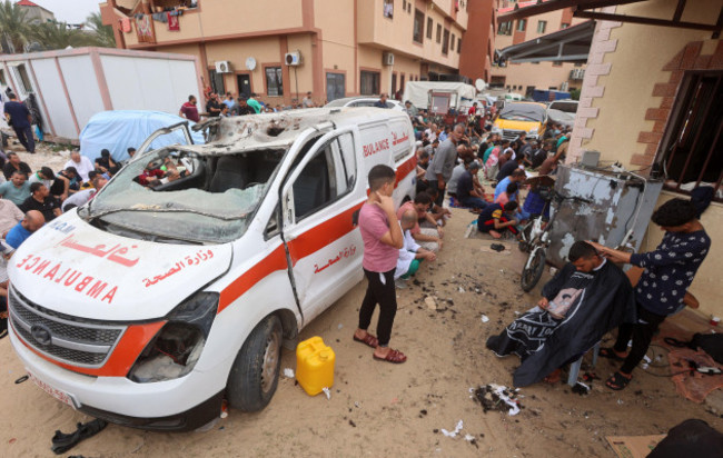 october-27-2023-palestinians-seated-on-the-ground-close-to-a-damaged-ambulance-take-part-in-friday-noon-prayers-in-the-driveway-of-the-emergency-entrance-of-the-nasser-hospital-in-khan-yunis-in-t