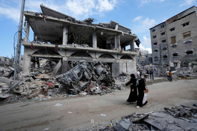 palestinians-walk-past-the-buildings-destroyed-in-the-israeli-bombardment-of-the-gaza-strip-at-the-main-road-in-bureij-refugee-camp-gaza-strip-tuesday-nov-14-2023-ap-photoadel-hana
