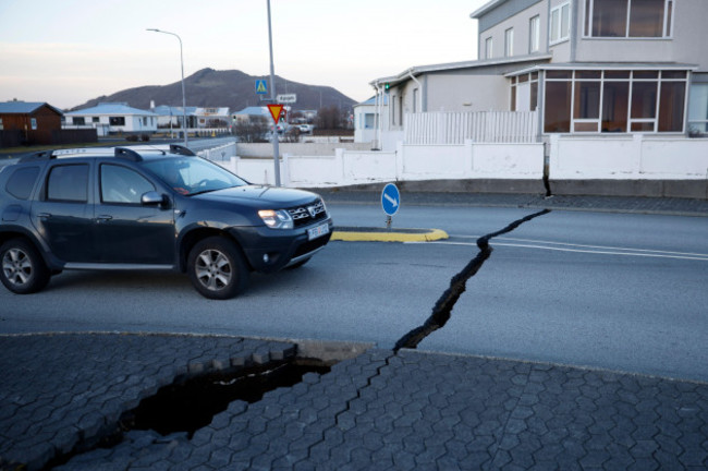 a-car-drives-toward-a-fissure-in-a-road-in-the-town-of-grindavik-iceland-monday-nov-13-2023-following-seismic-activity-residents-of-grindavik-a-town-in-southwestern-iceland-have-been-briefly-all