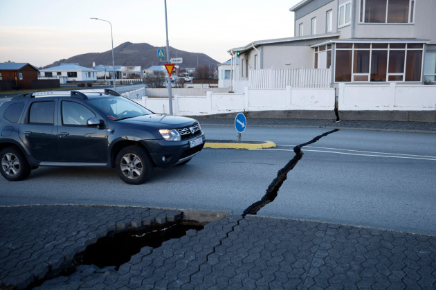 a-car-drives-toward-a-fissure-in-a-road-in-the-town-of-grindavik-iceland-monday-nov-13-2023-following-seismic-activity-residents-of-grindavik-a-town-in-southwestern-iceland-have-been-briefly-all
