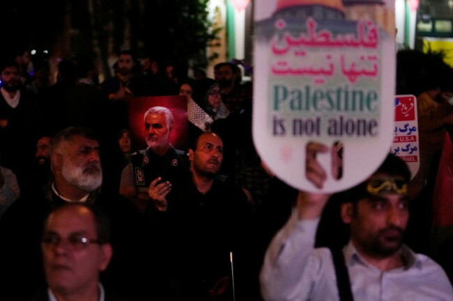 a-demonstrator-holds-a-poster-of-the-late-iranian-revolutionary-guard-gen-qassem-soleimani-who-was-killed-in-a-u-s-drone-attack-in-2020-as-the-other-one-holds-up-a-pro-palestinian-placard-during-a