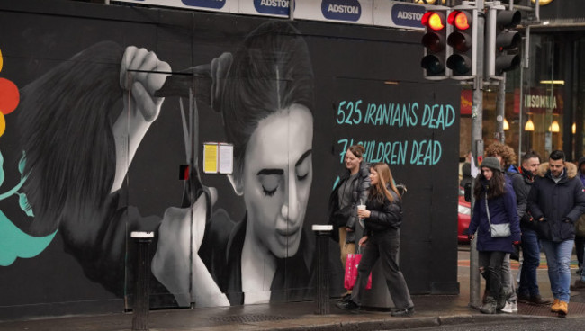 people-walk-past-a-mural-highlighting-the-plight-of-women-in-iran-on-dame-street-in-dublin-the-mural-by-group-of-female-artists-known-as-the-minaw-collective-has-the-words-woman-life-freedom-in