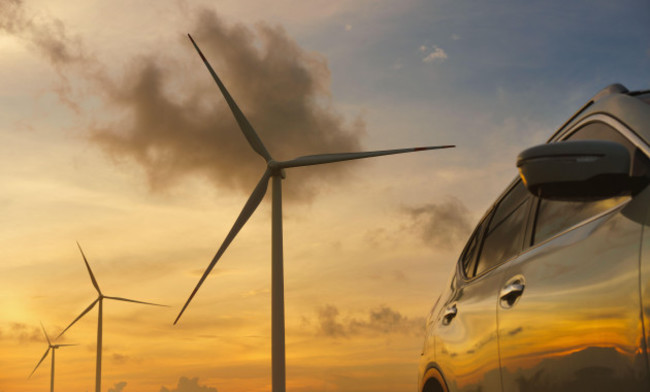 close-up-car-in-with-wind-turbines-and-sunset-backgrounds
