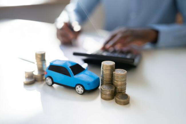 toycarinfrontofbusinessmancalculatingloan