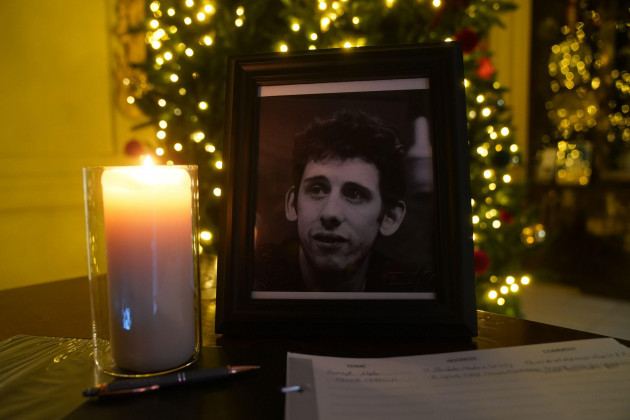 a-candle-burns-next-to-a-photograph-of-the-pogues-frontman-shane-macgowan-at-the-mansion-house-in-dublin-after-a-book-of-condolence-was-open-by-the-lord-mayor-of-dublin-following-the-announcement-o