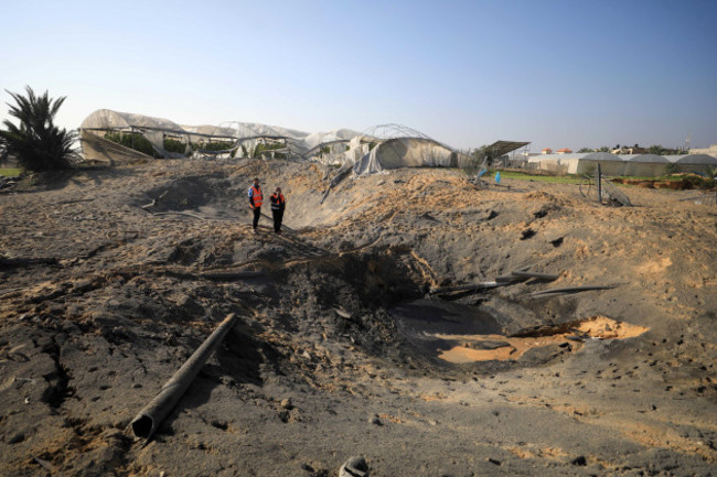 231202-khan-younis-dec-2-2023-xinhua-people-are-seen-around-a-damaged-road-after-israeli-airstrikes-in-the-southern-gaza-strip-city-of-khan-younis-dec-2-2023-a-total-of-15207-palesti