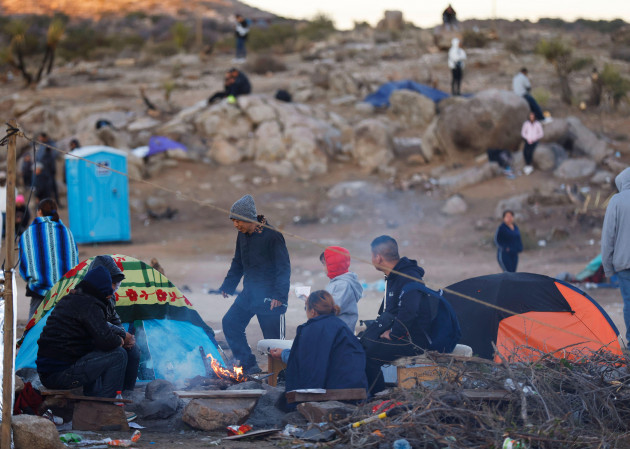 jacumba-hot-springs-california-usa-3rd-dec-2023-asylum-seeking-migrants-from-china-try-to-stay-warm-next-to-a-fire-in-an-open-air-holding-area-next-to-the-u-s-mexico-border-near-the-small-deser