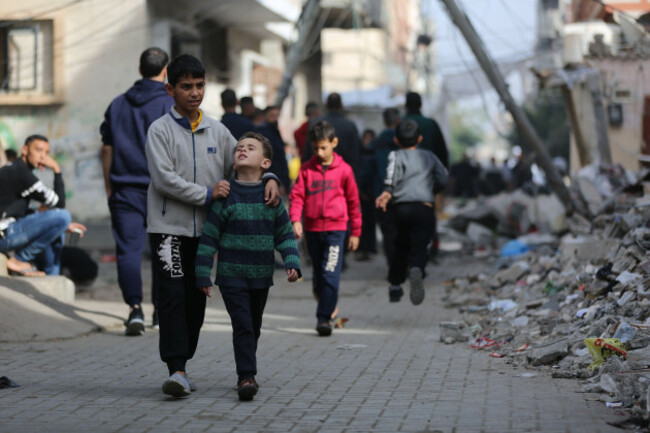 gaza-11th-dec-2023-people-walk-past-damaged-buildings-after-an-israeli-airstrike-in-maghazi-refugee-camp-central-gaza-strip-dec-10-2023-credit-xinhuaalamy-live-news