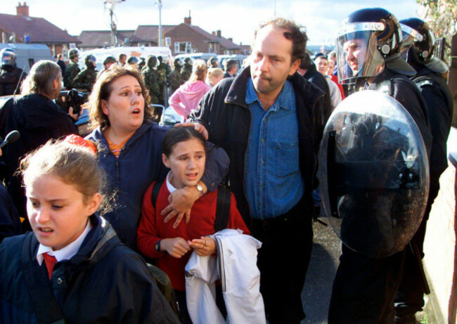 catholic-children-and-parents-make-there-way-under-the-protection-of-the-royal-ulster-constabulary-police-as-they-make-their-way-to-the-catholic-primary-school-holy-cross-which-is-situated-in-a-prot